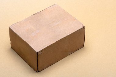 Tarafsız bir zeminde duran karton kutu teslimat, nakliye, nakliye ve ticaret endüstrisi gibi hizmetleri sembolize ediyor.