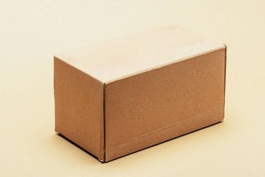 Hafif bir arka planda duran karton kutu nakliyat, teslimat, ticaret ve lojistik kavramlarını sembolize ediyor.