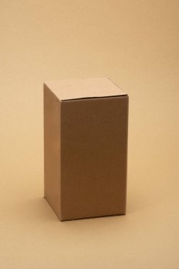 Tarafsız bir bej arka planda kahverengi karton kutu ticari teslimat, ambalaj ve lojistik, nakliye, paket servisi, depolama ve online alışveriş gibi kavramlar için idealdir.