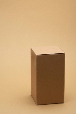 Temiz arka planda kapalı kapaklı uzun kahverengi karton teslimat kutusu, bol miktarda fotokopi alanı sunan, nakliyeyi, taşınmayı, ticareti ve sürdürülebilir ambalajı sembolize eden,