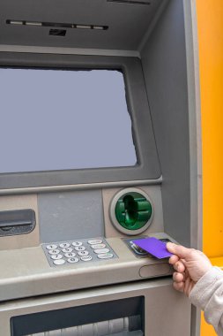 Finansal işlemler için otomatik veznedarın kredi kartını kullanan el, kişiselleştirilmiş içerik veya bilgi için kopyalama alanı sağlayan boş bir ekran