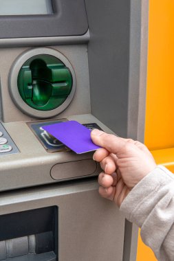 Nakit çekmek veya diğer bankacılık hizmetlerini gerçekleştirmek için otomatik veznedar kullanan kişi, modern finans, güvenli işlemler ve günlük kişisel bankacılık