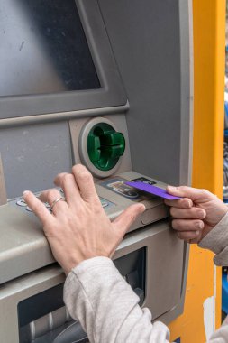Banka işlemleri için otomatik veznedar - ATM - ATM, yuvaya bir kredi kartı sokmak ve tuş takımındaki tuşlara basmak, bankacılık erişimini ve servisi göstermek