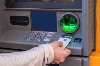 Banka işlemleri için bir ATM 'ye bir banka kartı eklemek, para çekme veya para çekme makinesinin klavyesinde yeşil ışıkla aydınlatılmış bir depozito işlemek