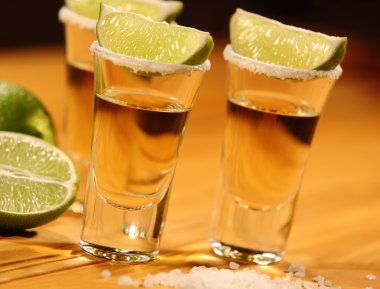 Üç kısa bir dilim limon ve tuz yanında alkol ile eski rustik masa vintage doku ile bardaklar