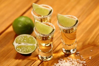 Üç kısa bir dilim limon ve tuz yanında alkol ile eski rustik masa vintage doku ile bardaklar