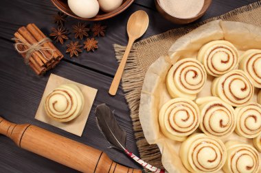 Yumurta ve mutfak araçları bir arka plan siyah kurulların rustik tablosunun yanındaki kavurma için hazırlanmış çiğ tarçın rulo