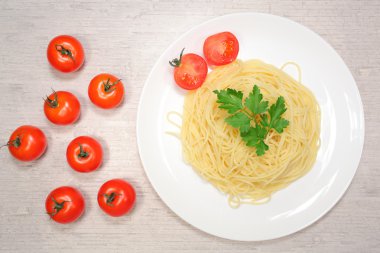 İtalyan yemek: makarna kırmızı kiraz domates ve yeşil zeytin yanında büyük beyaz tabakta