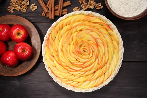 Products and ingredients for making homemade apple pie, spread out on a rustic table in a plates and bowls — 스톡 사진