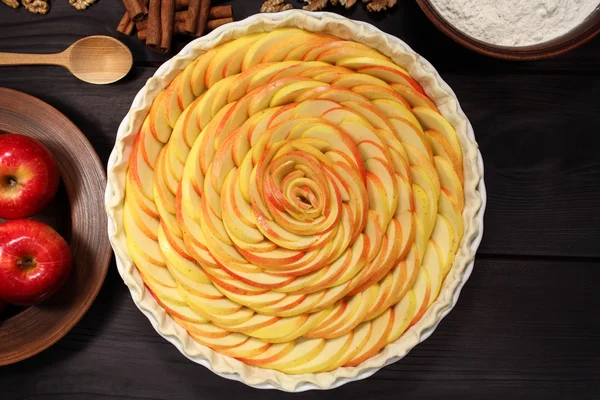 Products and ingredients for making homemade apple pie, spread out on a rustic table in a plates and bowls — 스톡 사진