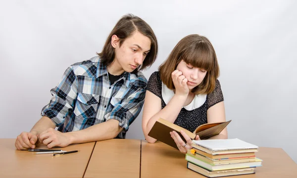 Teenager looks at a book that holds the girl Stock Picture