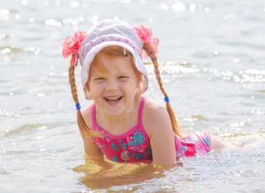 Küçük kızıl saçlı kız nehirde banyoları