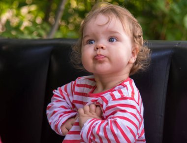 Küçük kız kalemlerle yukarı bakıyor.