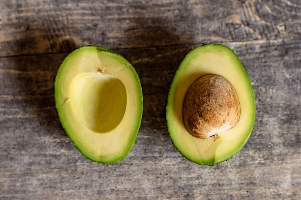Harika sulu bir avokado, büyük bir çukurla ikiye bölünmüş..