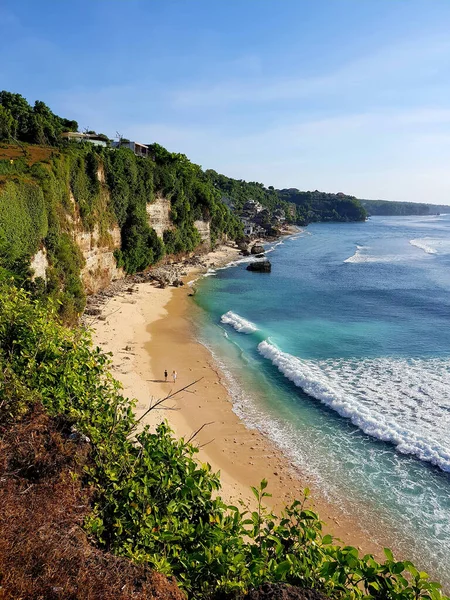 Okyanus kıyısı, temiz, güzel, ışık dalgalı yaz plajı. İki, bir adam ve bir kadın, sahilde yürüyorlar..