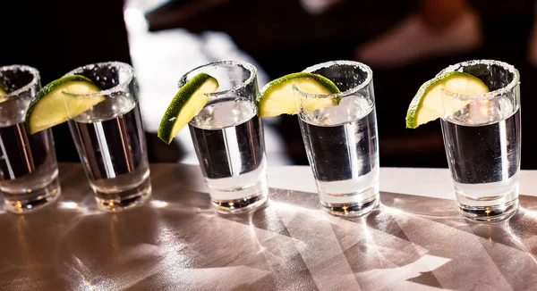 Limon dilimleri ve tuzla süslenmiş alkollü içecekler.