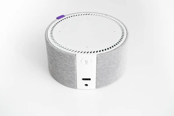 Gri ve beyaz tonlarda küçük, yuvarlak bir sütun beyaz bir masada duruyor..