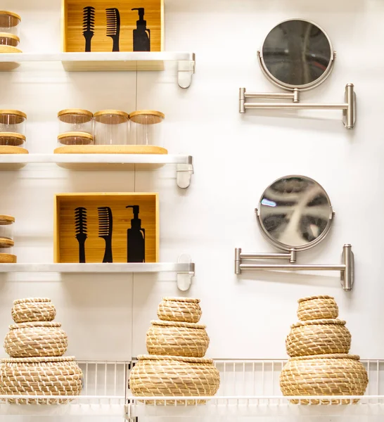 Tuvalette. Raflar, konteynırlar, hasır sepetler ve bir ayna..