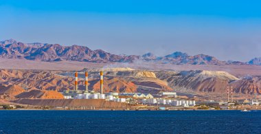 Oil refinery on Red Sea rocky coast clipart