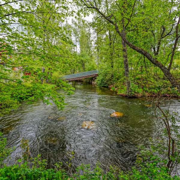 Pedestrian wooden bridge over stream — Stock Photo, Image