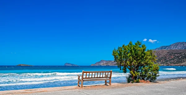 Одна скамейка на берегу моря — стоковое фото