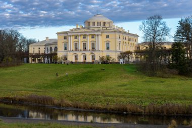 PAVLOVSK, RUSSIA - 07 Kasım 2020: Pavlovsk Sarayı 'nın cephe manzarası, İmparator I. Paul' un Pavlovsk 'taki yazlık sarayı, Slavyanka nehrinin kıyısında sonbahar akşamı. St. Petersburg banliyösü, Rusya.