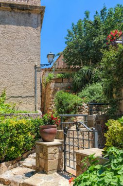 Katalonya, İspanya 'daki Tossa de Mar' ın ortaçağ labirentlerinde tropikal bitkilerle dolu dar kaldırım taşlı dalgalı sokaklar. Güney Avrupa 'nın ünlü turizm beldesi.