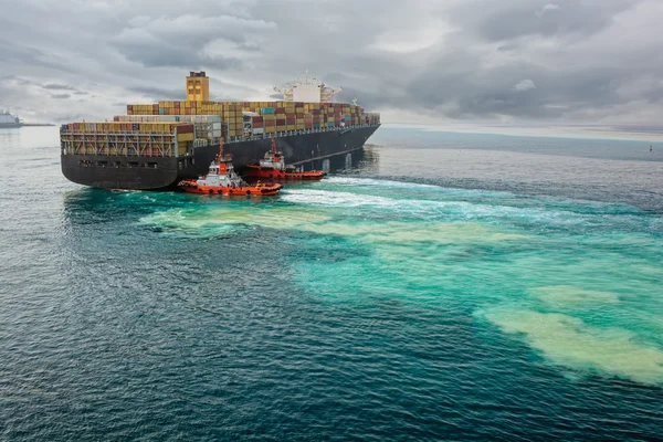 Tugboats assisting container ship — Stock Photo, Image