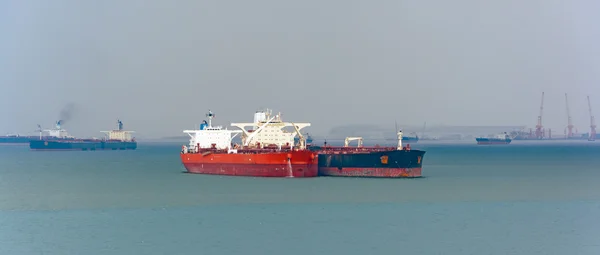 Loading anchored oil supertanker via a ship-to-ship oil transfer — Stock Photo, Image