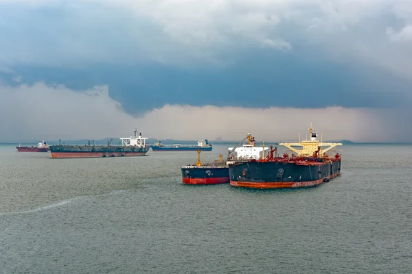 Stock image Loading anchored oil supertanker via a ship-to-ship oil transfer