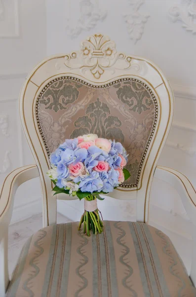 Blå och lila blomma bouqet liggande på vit gammal stol — Stockfoto