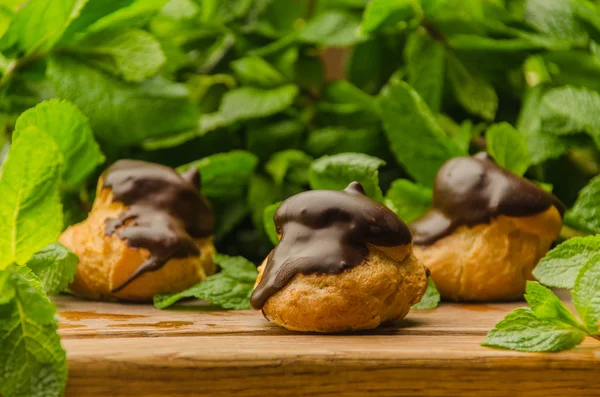 Chocolade ahşap tahta üzerinde Fransız eklerleri kaplı
