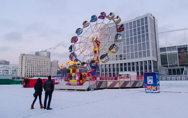 Kiev /Ukraine - Ocak 2016: Genç çift yol renkli atlıkarınca çeviriyor izliyor yuvarlak. 03 Ocak 2016, Kiev, Ukrayna
