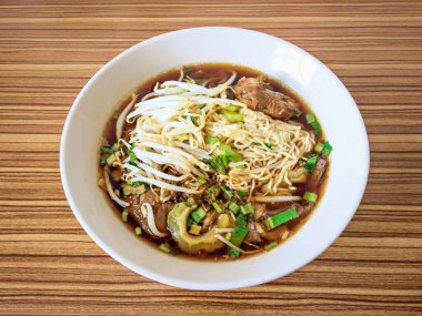 Ahşap zemin üzerinde acı kabakla haşlanmış tavuk çorbası.