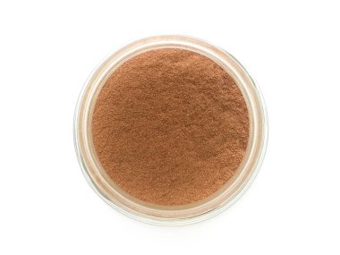 Beyaz arka planda cam bir şişede kakao tozunun üst görüntüsü