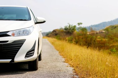 Kamboçya, Tayland - 28 Ocak 2018: Sarı çimlerin yanındaki beyaz sedan araba parkı.