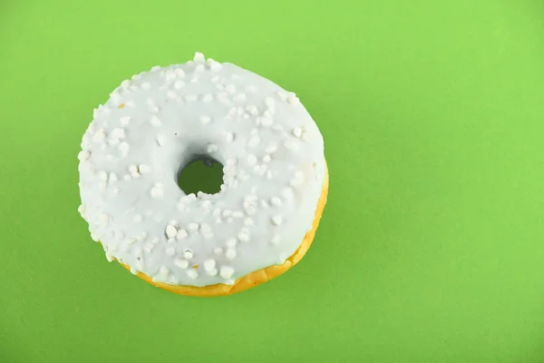 Donut con esmalte azul espolvorea sobre papel verde —  Fotos de Stock