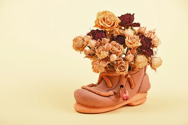 Dried roses bouquet in ceramic shoe — Stock Photo, Image