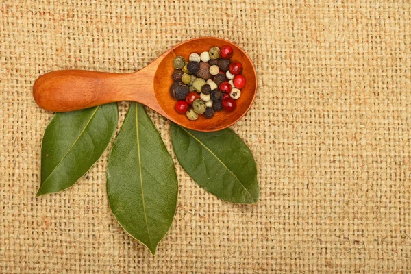 Bay leaves and peppercorn scoop on burlap canvas Stock Photo