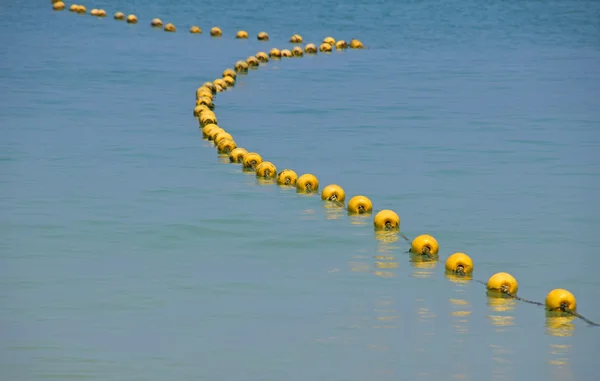 Chaîne de bouées jaunes en eau de mer bleue — Photo