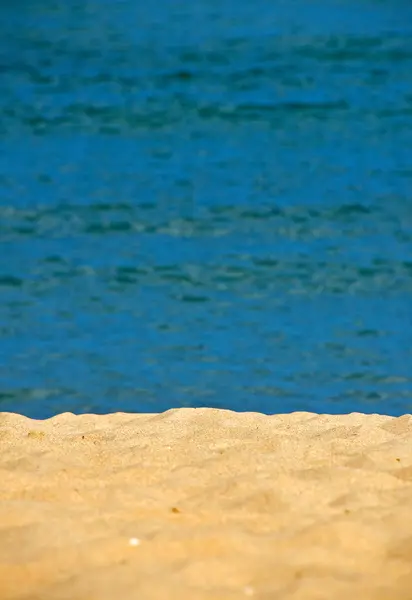 Plage de sable avec fond d'eau bleue — Photo