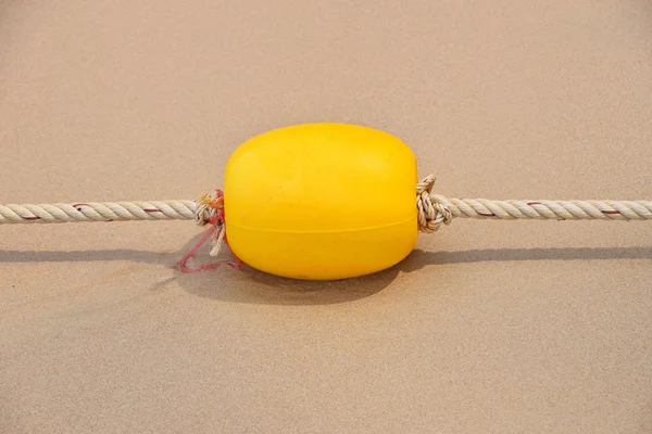 Boya marcadora amarilla en playa de arena — Foto de Stock
