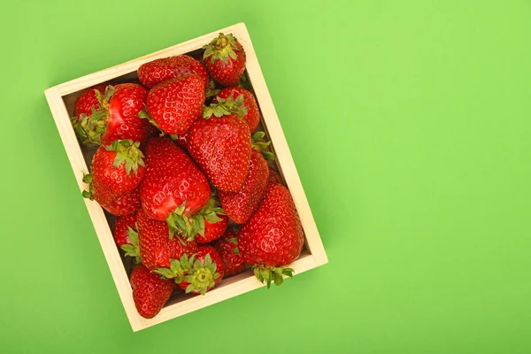 Erdbeere in Holzkiste über Grün — Stockfoto