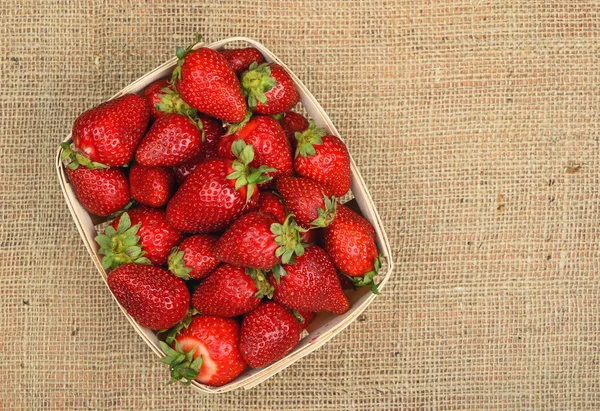 Strawberry in wooden basket on jute canvas — Stock Photo, Image