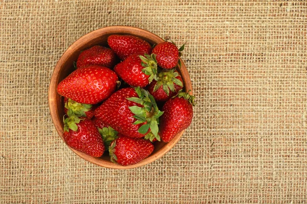 Erdbeere in Keramikschale auf Jute-Leinwand — Stockfoto