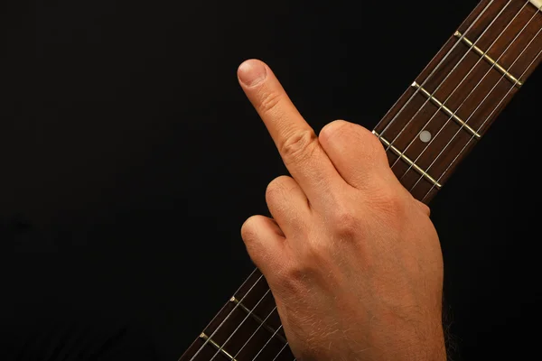 Hombre mano en la guitarra cuello mostrando dedo en negro — Foto de Stock