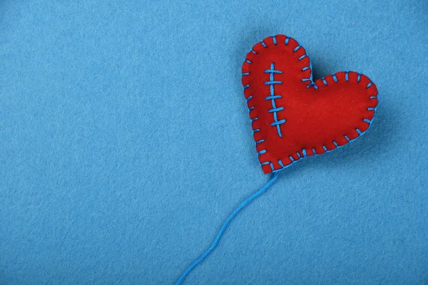 Пояс ремесел і мистецтво червоне серце, нитка на синьому — стокове фото
