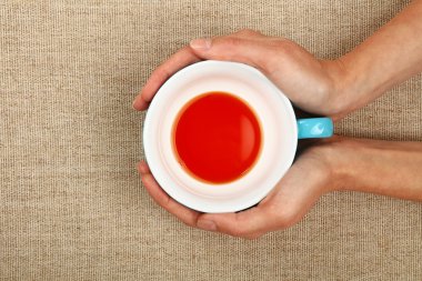 Siyah kırmızı çay tutan iki kadın eli