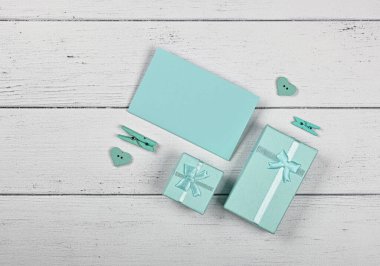 Sevgililer günü nane rengi deniz mavisi hediye kutuları kurdele başlıkları ve beyaz ahşap masa arkaplanı üzerine kağıt not, düz yatağı kapat, üst görünümü tam üstte.
