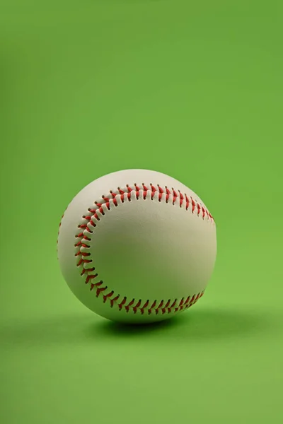 Yeşil Arka Planı Kırmızı Dikişli Düşük Açılı Yeni Bir Beyzbol — Stok fotoğraf